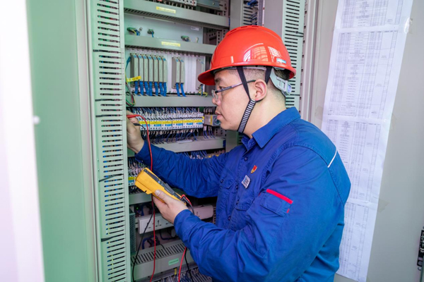 呂曉勇在保護盤柜前檢查二次回路接線情況。受訪者供圖