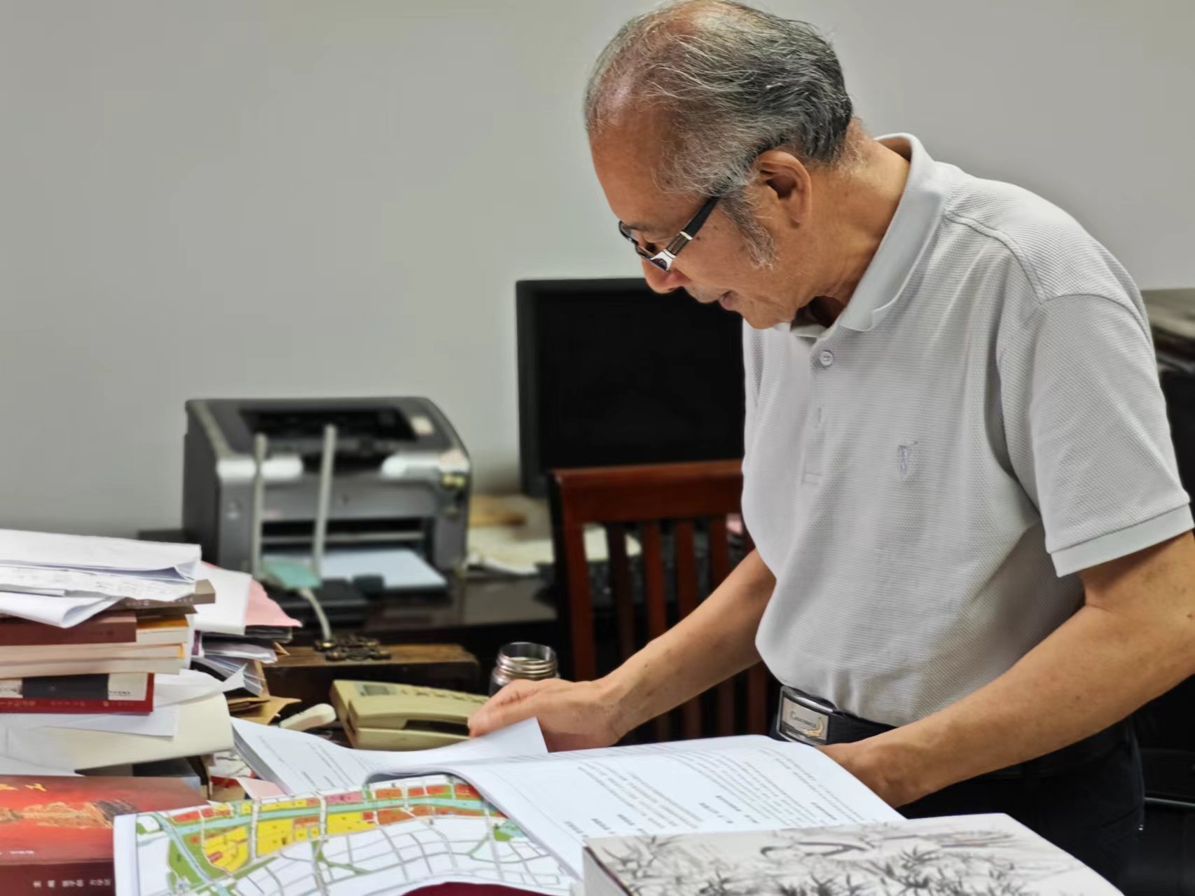 顧風在辦公室翻閱資料。人民網(wǎng)記者 黃鈺攝