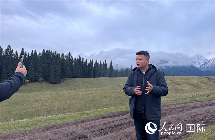 在庫爾德寧，吾買爾江被雪山美景震撼，即興錄制了短視頻作品。人民網記者曾書柔攝