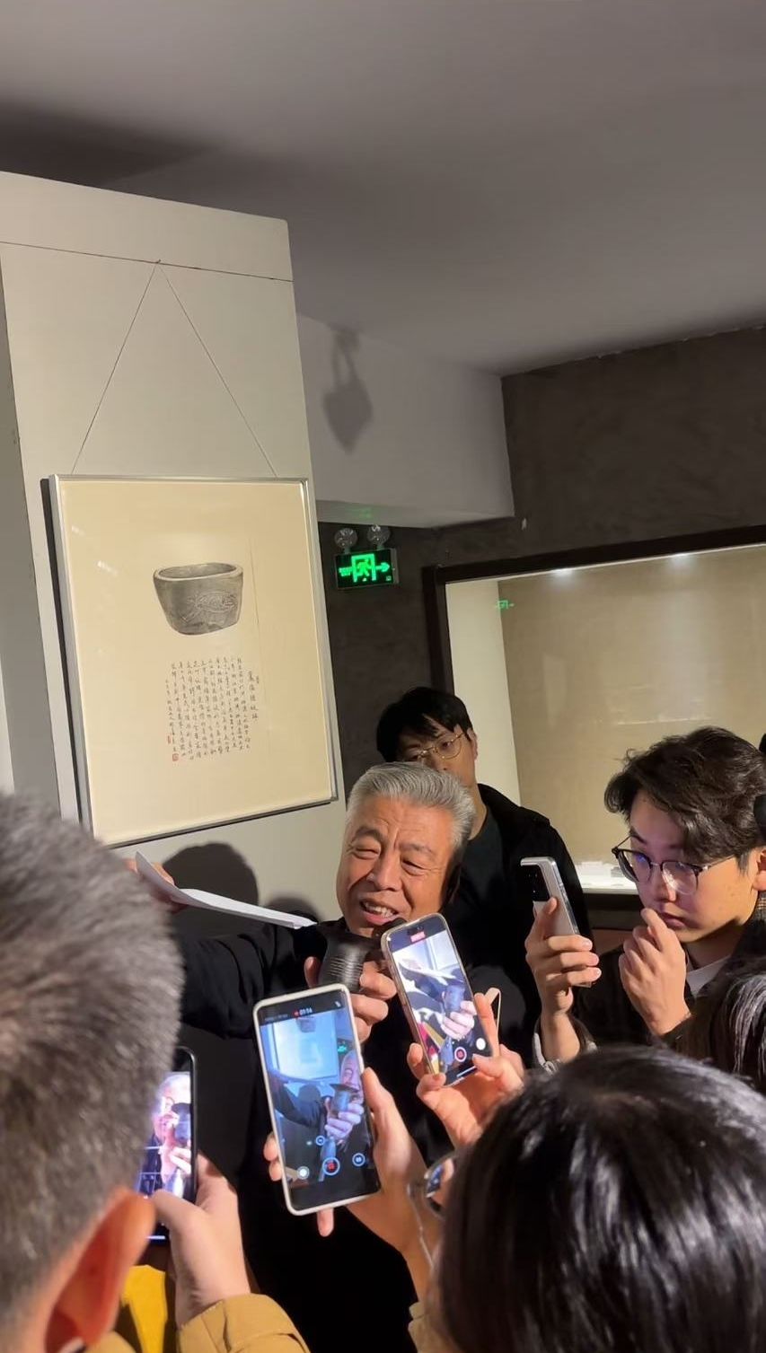 黑陶邢文化博物館館長邢葆東展示兩張相疊的A4紙，向記者解釋此為杯口的厚度。