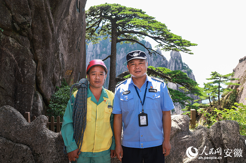 全國道德模范李培生（左）和胡曉春在迎客松前合影。人民網(wǎng)記者 張俊攝