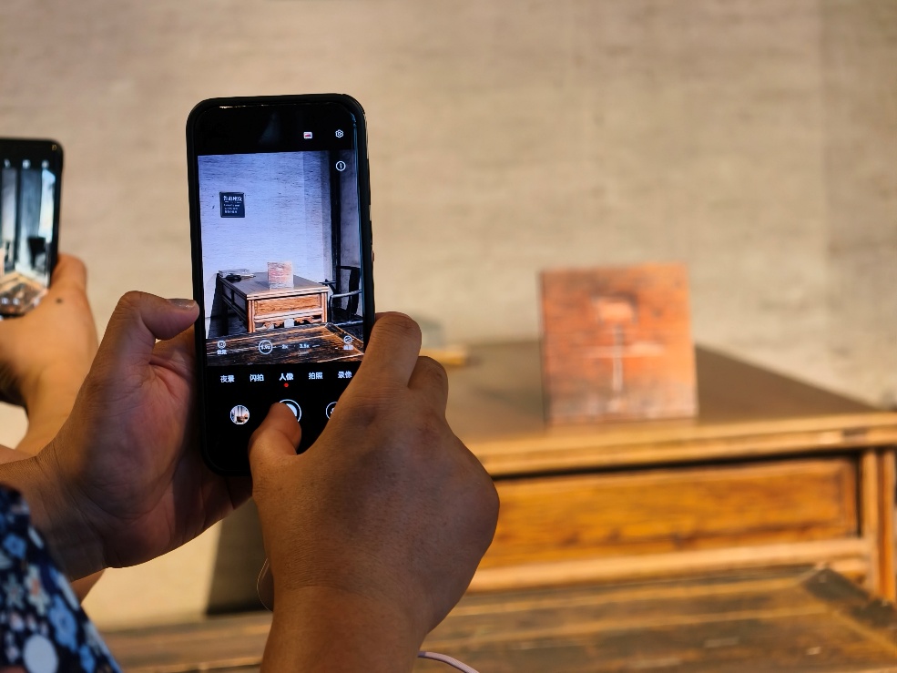 2025年7月15日，暑期研學(xué)團(tuán)小朋友在浙江省紹興市三味書屋拍攝魯迅讀書座位及課桌上的“早”字。受訪者供圖