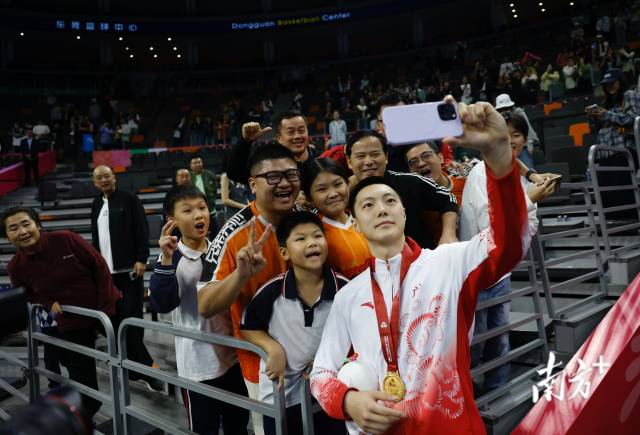 11月12日，十五運(yùn)會男籃成年組決賽，廣東隊(duì)獲得冠軍后，胡明軒與球迷們合影留念。張由瓊 攝