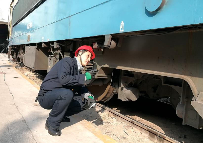韓文盛全神貫注檢查機(jī)車走行部。