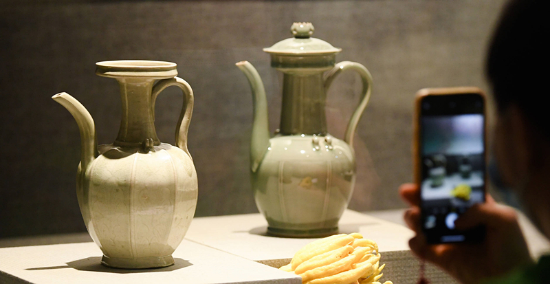 2021年9月14日，浙江省博物館，觀眾在拍攝北宋龍泉窯執(zhí)壺（左）和龍泉青瓷藝人劉杰制作的執(zhí)壺。