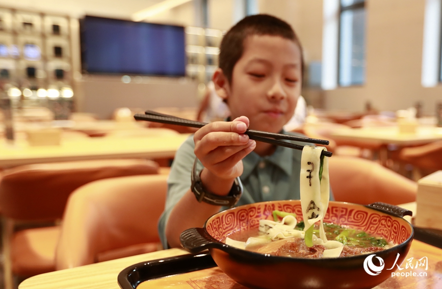 殷墟博物館推出的甲骨文面深受游客喜愛。人民網(wǎng)記者 慎志遠(yuǎn) 攝