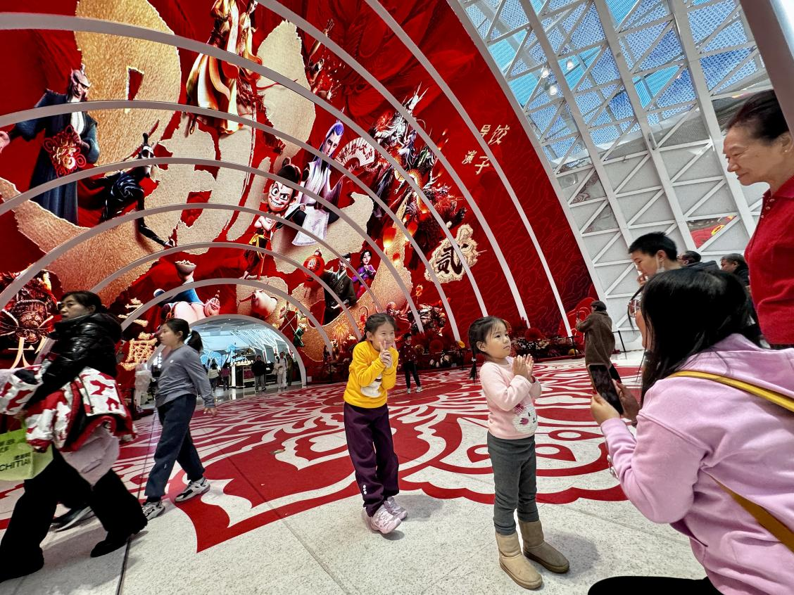 乙巳蛇年春節(jié)期間，影迷在《哪吒之魔童鬧?！肪薹?bào)前拍照打卡。