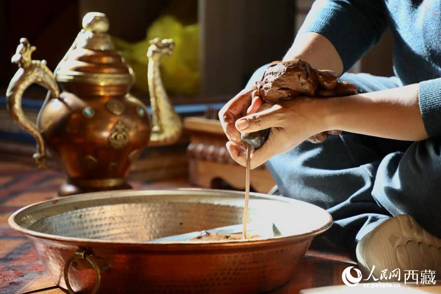 牛角鉆孔，將木泥擠出。人民網(wǎng)記者 次仁羅布攝