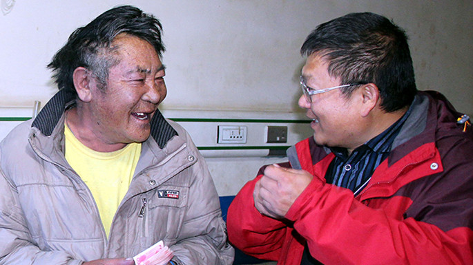6、這是中國石化援藏干部王鵬雁（右）來到???結對子”幫扶對象的扎扎（左）家中，為他妻子英秋治病送去自掏腰包的??????需的治療費（扎??2014??7??9日攝）_副本.jpg