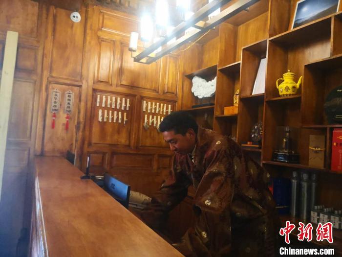 圖為桑杰才讓用電腦處理財務(wù)?！∈缝o靜 攝