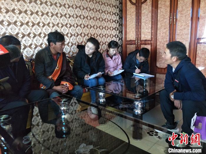 圖為調(diào)查組工作人員正在入戶調(diào)查?！∑钤鲚?攝