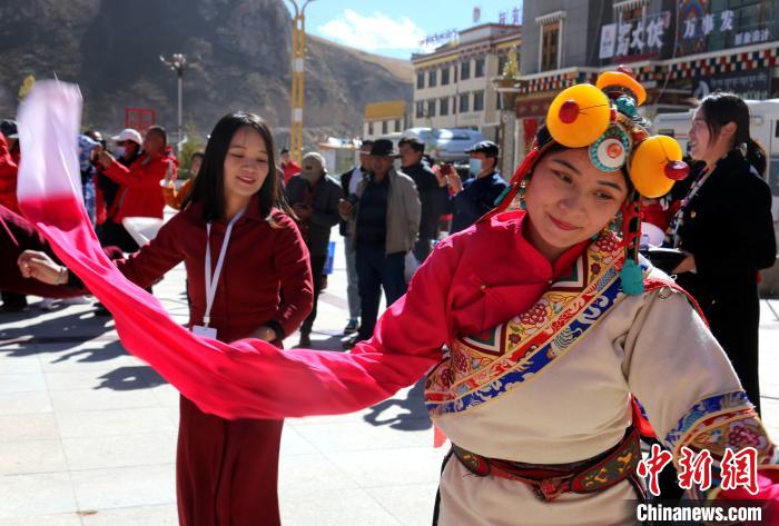 圖為中外記者向當?shù)孛癖妼W習民族歌舞文化?！?zhí)砀?攝