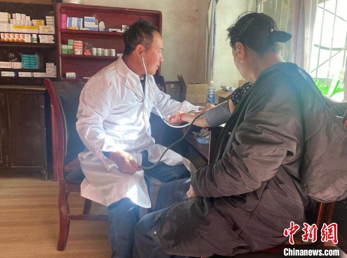 索木滾(左)為村民看病。　壤塘縣委宣傳部供圖