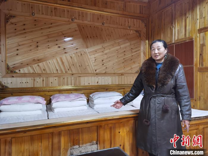 圖為德吉村村民鬧尖措介紹自家農(nóng)家樂?！∑钤鲚?攝