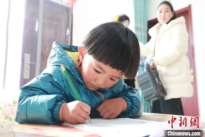 孩子們?cè)诩议T口上學(xué)，是楊周馬草搬入蘭州新家最為開心的事情。小女兒楊洋正在學(xué)習(xí)寫數(shù)字。　魏建軍 攝