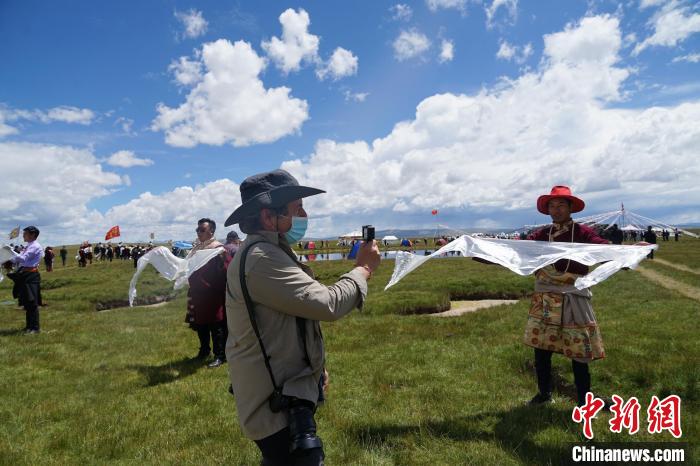 圖為一名外籍?dāng)z影師記錄當(dāng)?shù)夭刈鍤g迎儀式?！●R銘言 攝