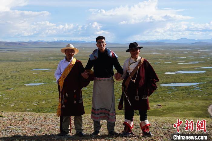 圖為一名留學(xué)生身穿自己國(guó)家的服飾和藏族民眾合影留念?！●R銘言 攝