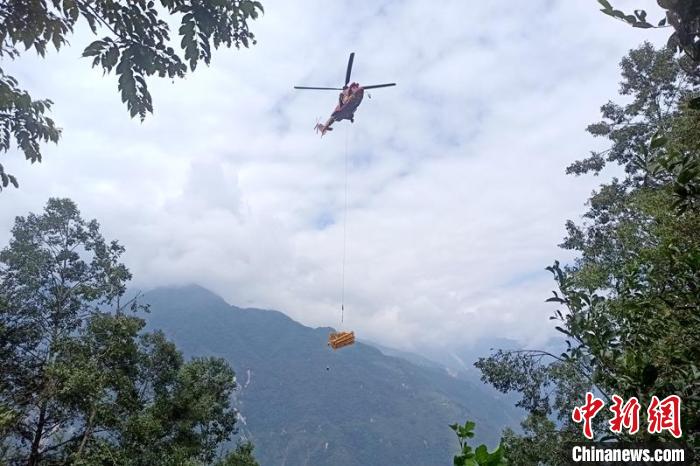直升機起飛將搶修塔材運往海拔1950米的110千伏唐下線29號塔位?！⌒鞈c明 攝