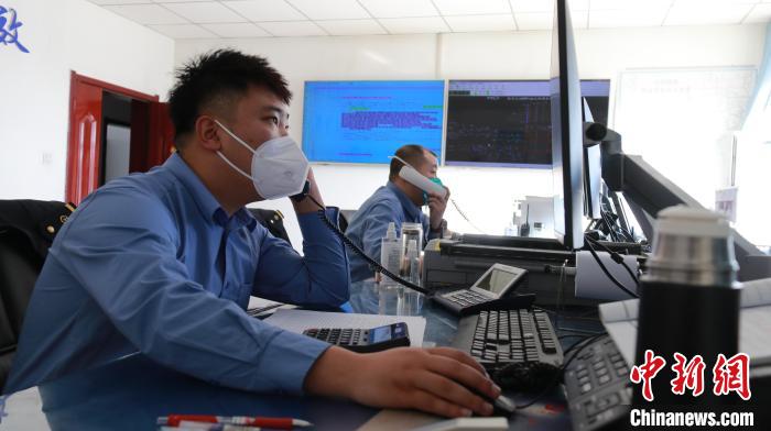 圖為貨運(yùn)調(diào)度人員與外勤工作人員聯(lián)系掌握車輛裝載情況?！±钌?攝