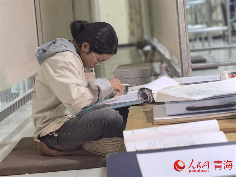 正在學(xué)習(xí)畫(huà)底稿的尕讓旺姆。人民網(wǎng) 陳明菊攝