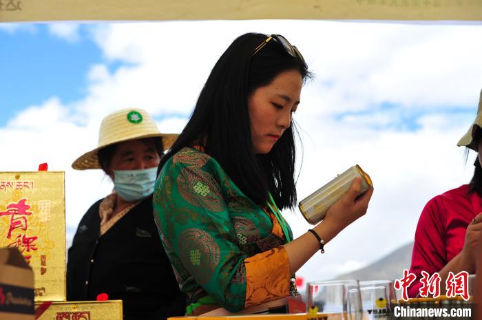 圖為拉薩市民在特色農(nóng)畜產(chǎn)品展示展銷會上選購商品?！垈?攝