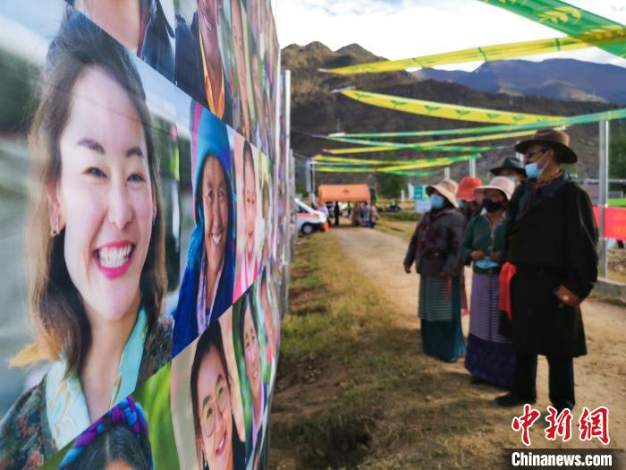 圖為當?shù)孛癖娫谟^看展板上的笑臉。　張偉 攝