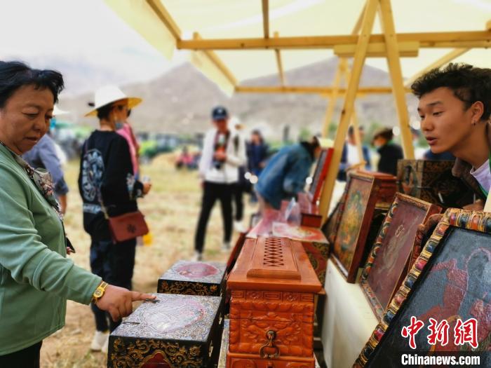 圖為拉薩市民在特色農(nóng)畜產(chǎn)品展示展銷會上選購商品?！垈?攝