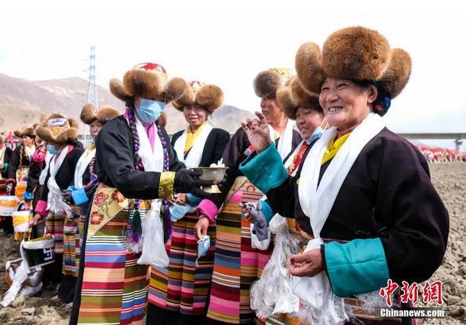 資料圖：西藏自治區(qū)拉薩市曲水縣才納鄉(xiāng)協(xié)榮村參加春耕儀式的村民互敬青稞酒。按照傳統(tǒng)，當(dāng)?shù)卮迕裆碇?jié)日盛裝，舉行隆重的儀式，祈福一年的豐收。<a target='_blank' ><p  align=
