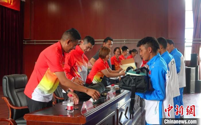 圖為世界冠軍們?yōu)槲鞑刈灾螀^(qū)體校的學(xué)生們送上暖心物資。　冉文娟 攝