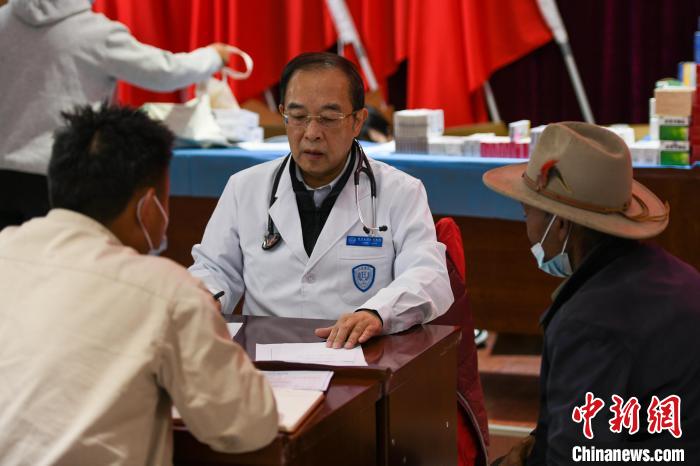 北京大學人民醫(yī)院心臟中心副主任、博士生導師王偉民為農牧民問診。　江飛波 攝