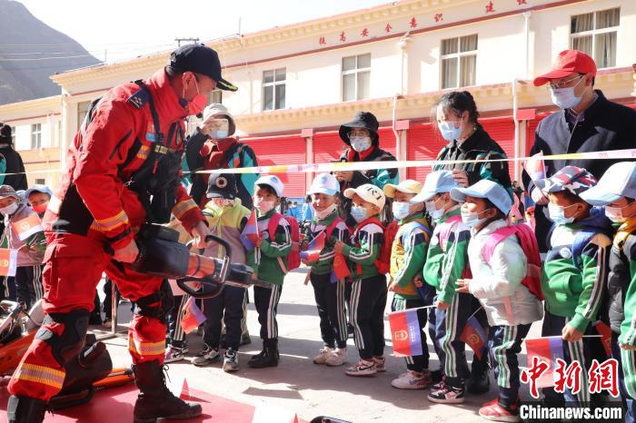 圖為消防指戰(zhàn)員為學(xué)生講解、演示先進(jìn)救援裝備?！≮w琳 攝