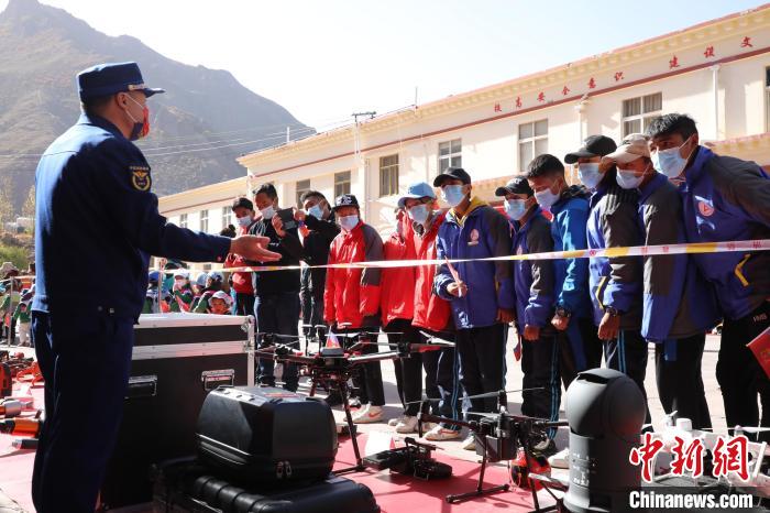 圖為消防指戰(zhàn)員為學(xué)生講解、演示先進(jìn)救援裝備?！≮w琳 攝