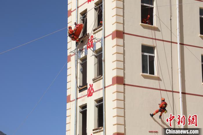 圖為消防指戰(zhàn)員進(jìn)行繩索救援演練。　朱科熹 攝