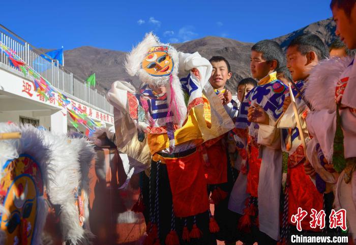 圖為加查縣安繞鎮(zhèn)小學(xué)學(xué)生在試穿藏戲面具?！∝暩聛硭?攝