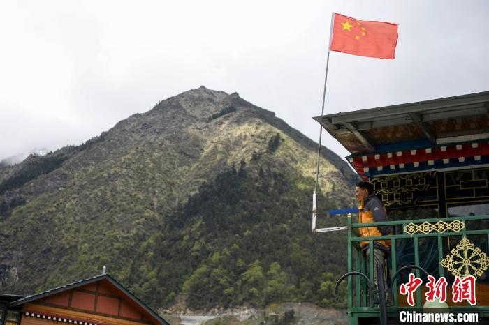 村民站在樓房上觀望。　楊華峰 攝