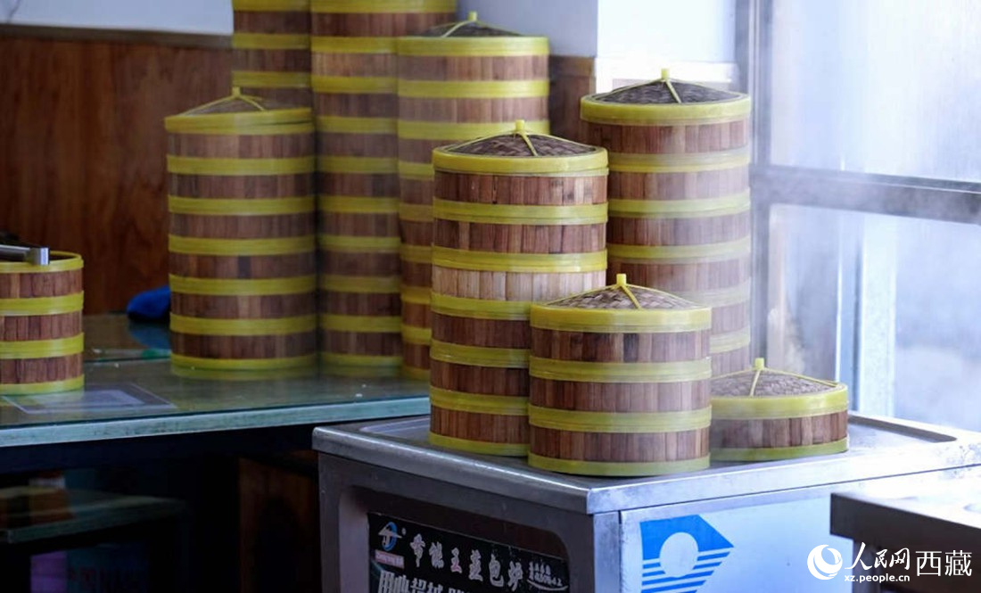 電蒸箱上擺滿了多屜熱氣騰騰的包子。人民網(wǎng) 次仁羅布攝