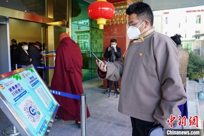 圖為政協(xié)委員掃場所碼進(jìn)入會場。　江飛波 攝