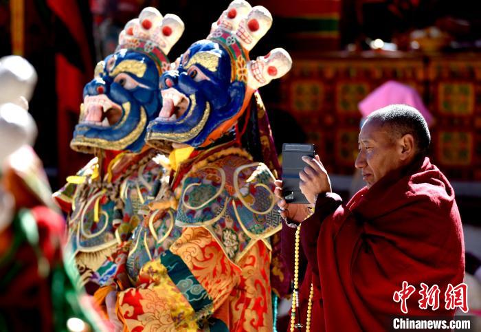 2月19日，正在拍攝跳神活動的僧人。　李林 攝