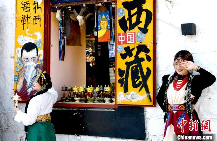 4月17日，游客身著藏式元素服裝在拉薩八廓街拍照留念?！±盍?攝