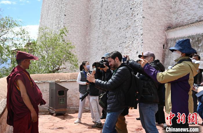 圖為中外媒體拍攝朝拜布達拉宮的僧人?！≮w朗 攝