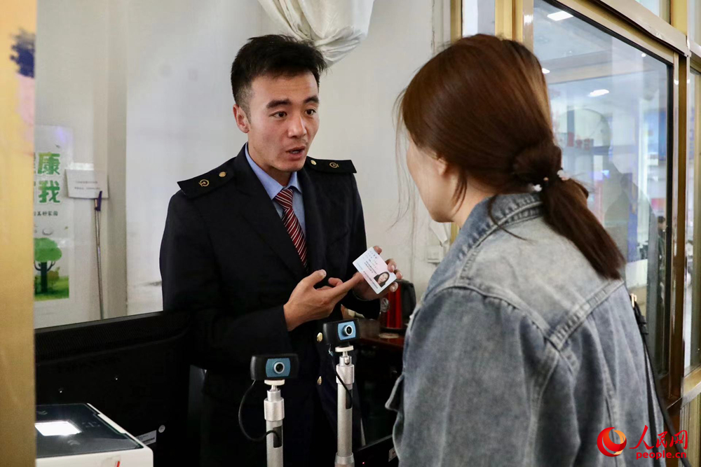 車站工作人員向旅客解答疑問。人民網(wǎng)記者 次仁羅布攝