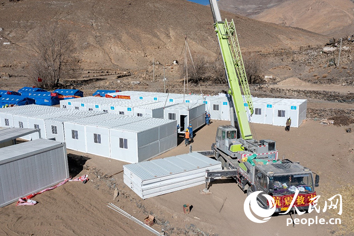 1月9日，在日喀則市定日縣長(zhǎng)所鄉(xiāng)古榮村安置點(diǎn)，救援人員和施工人員合力抓緊搭建移動(dòng)板房，確保受災(zāi)群眾溫暖過冬。人民網(wǎng)記者 翁奇羽攝
