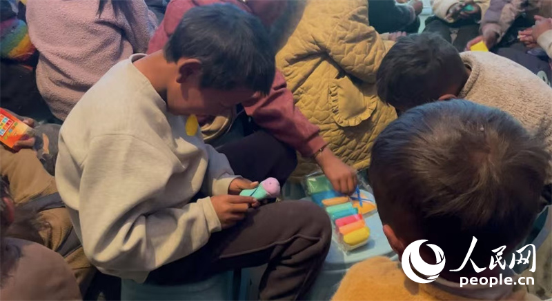 措果鄉(xiāng)塘仁村的孩子們正在用橡皮泥制作自己的情緒“小怪獸”。人民網(wǎng)記者 郝潔攝