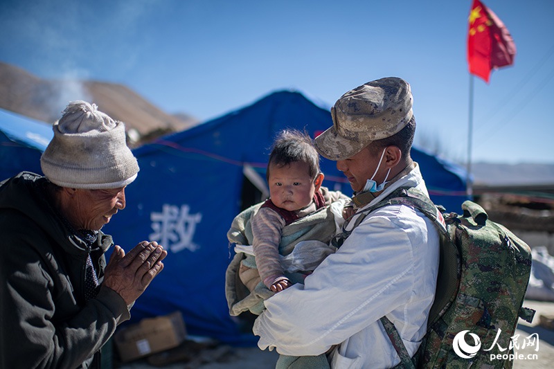 1月9日，在定日縣長所鄉(xiāng)古榮村安置點，受災(zāi)群眾感謝西藏軍區(qū)陸軍某部隊衛(wèi)生員的醫(yī)療救治。人民網(wǎng)記者 翁奇羽攝