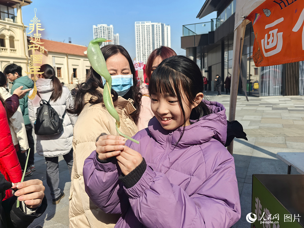 2025年1月29日，湖北武漢的新春廟會上，小朋友拿著吹制好的糖人，十分開心。人民網(wǎng)記者 張沛攝
