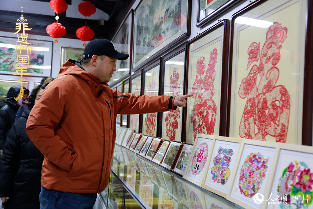 2025年1月23日，游客在天津楊柳青古鎮(zhèn)欣賞傳統(tǒng)剪紙作品，感受指尖上的古老藝術(shù)。人民網(wǎng)記者 崔新耀攝