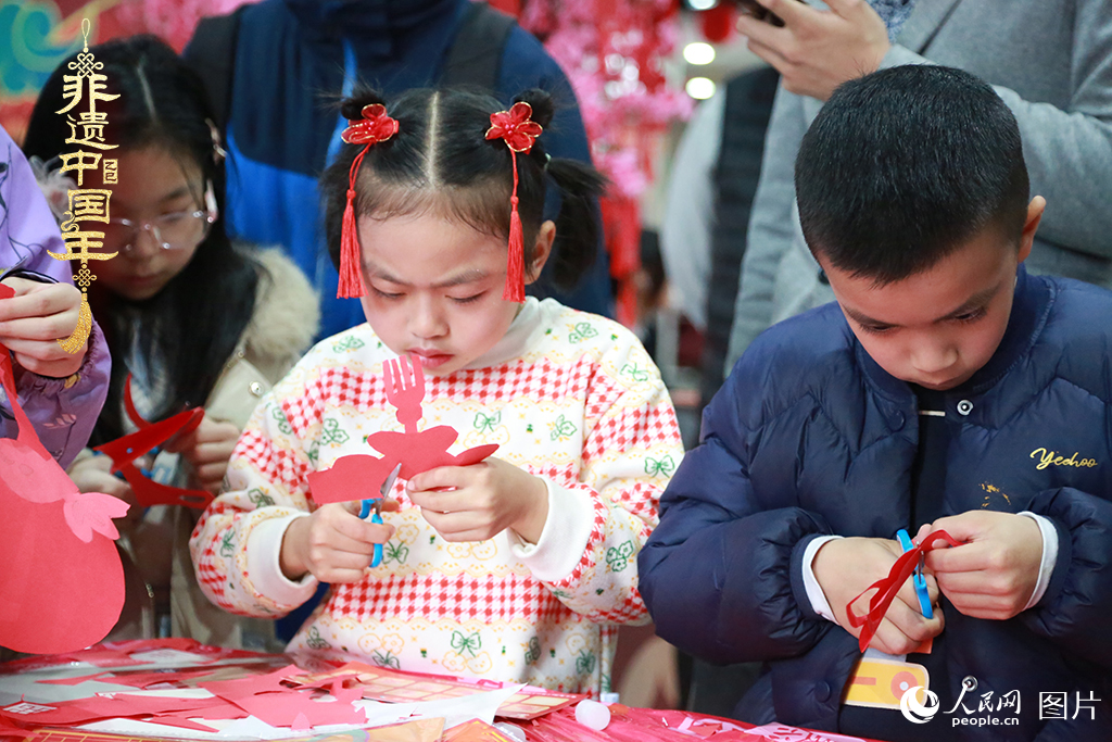 2025年1月23日，上海市青少年活動中心迎新春游園會上，小朋友們正在學習剪窗花。人民網(wǎng)記者 龔莎攝