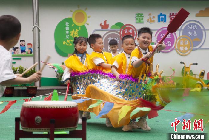 圖為龍舟賽游戲上，小伙伴們打鼓加油?！《^生 攝