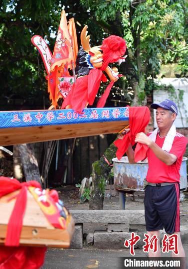 圖為5月29日，長(zhǎng)樂(lè)江田鎮(zhèn)村民為即將入水的新龍舟系紅布。　張斌 攝