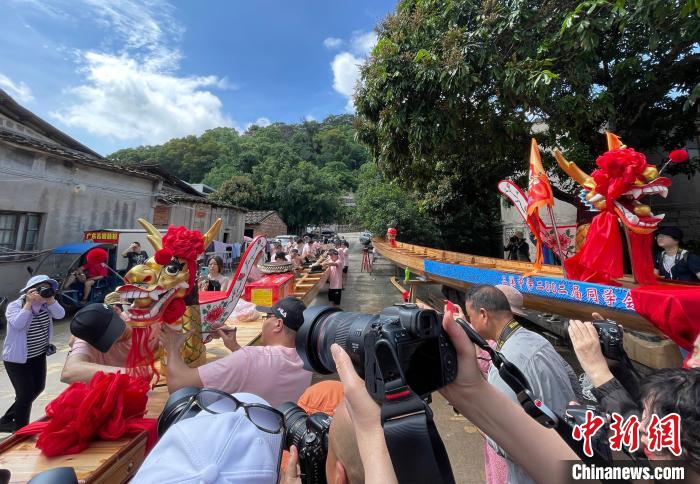 圖為5月29日，長(zhǎng)樂(lè)江田鎮(zhèn)村民為即將入水的新龍舟安裝龍頭。　張斌 攝